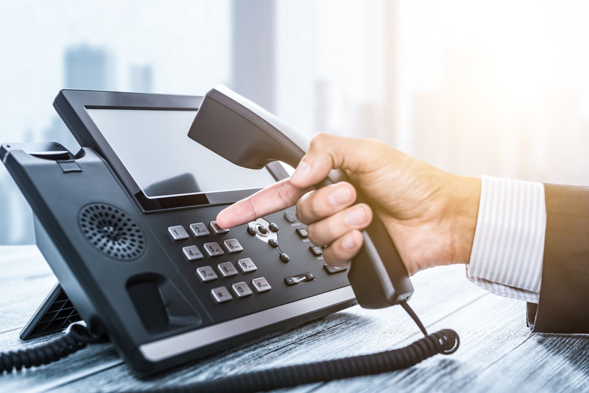Dialling a Yealink VoIP desk phone in a bright office